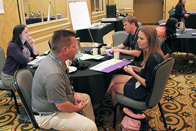 Participants have discussions around the table.