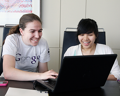 Image of a mentor working with a student on a laptop