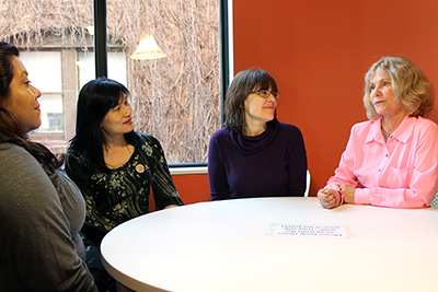 Sheryl sits at a table with participants.