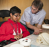 An educator shows a student some neurobiology materials.