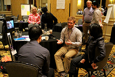 A group, including Brad on the Beam Robot, discusses ideas.