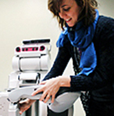 An Engineering professor positions a robot during a demonstration