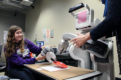 Erika uses a robot to move objects.