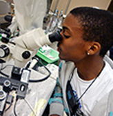 A student with a disability uses a microscope in a lab