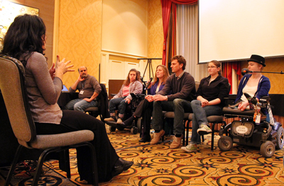 A sign language interpreter sits in front of the panel of student presenters.