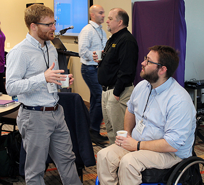 Two participants discuss ideas over coffee at the AccessEngineering capacity building institute.