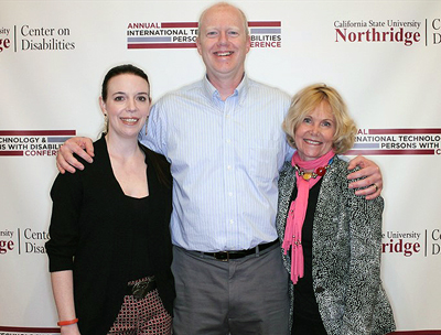 Tami Tidwell, Terrill Thompson, and Sheryl Burgstahler standing in front of the CSUN banner.