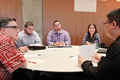 A student gives their elevator pitch while four others watch and give feedback.