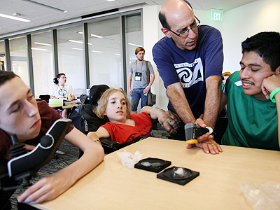 A teacher showing three students how to use some equipment at Summer Study 2014.