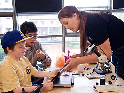 A teacher from Exo Labs working with two students at Summer Study 2014.