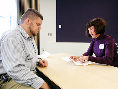 A student sitting across the table from a professional at Summer Stdy 2014.