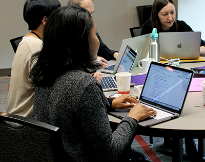 A woman works at a computer at a conference table.