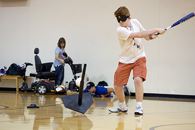 -	Phase I Scholar Jarrod takes a swing at beeping baseball at the accessible sports expo during Summer Study 2016.