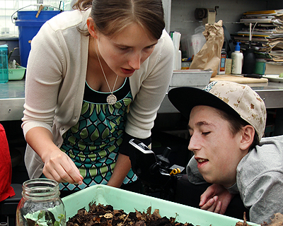 Image of a student working in a botany lab with the assistance of a PCA