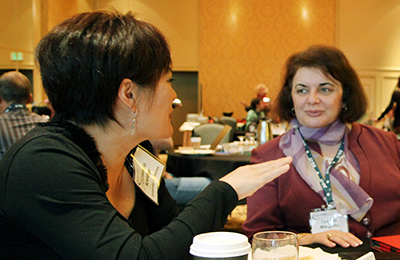 Two faculty members talk while sitting. Two faculty members talk while sitting.