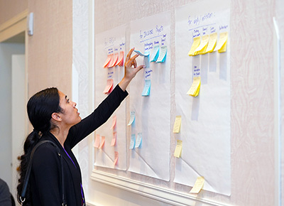 A participant leafs through post-it notes with promising practices on them.