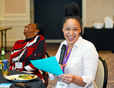 A participant shares from a discussion sheet. A participant shares from a discussion sheet.