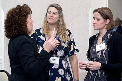 Three participants discuss ideas.