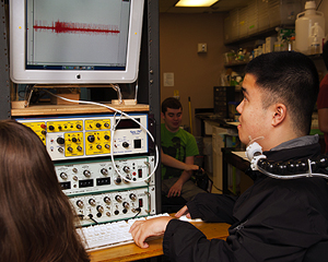A student with a disability works on computing data equipment.