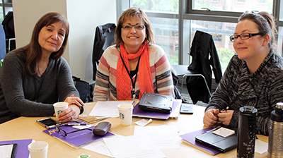 Three participants smile at the camera.