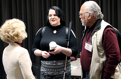 Two participants talk to AccessCyberlearning director Sheryl Burgstahler.