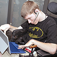 A student in a wheelchair uses a tablet with attachable keyboard.