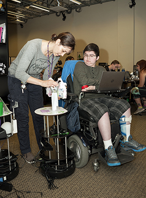 Maya Cakmak helps a Scholar with his robot during the robotics workshop at Summer Study 2016