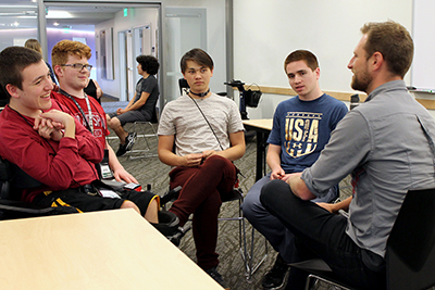 Summer study students sit with a mentor. Summer study students sit with a mentor.