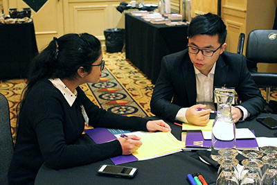 Two people sit at a table discussing the topic at hand. Two people sit at a table discussing the topic at hand.
