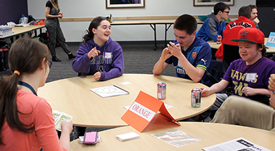 A group of students get to know each other while playing cards at a campus meet up.