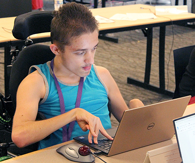 A student uses a laptop to write code for a computer science project.