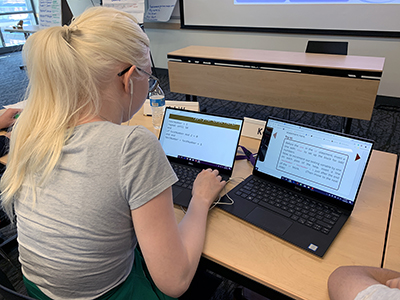 A student uses screen enlarging technology on two computers.