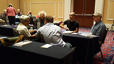 Participants of the AccessCS10K CBI gather around a table, discussing ideas. Participants of the AccessCS10K CBI gather around a table, discussing ideas.