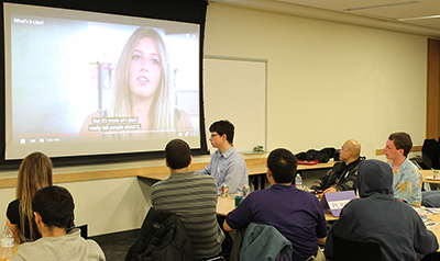 Participants watch a DO-IT video at a networking event.
