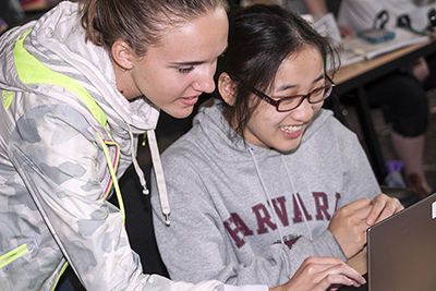 Phase I Scholars Emily and Chana laugh while using a computer.