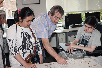 CSNE Director Eric Chudler shows two Scholars some information about brains.