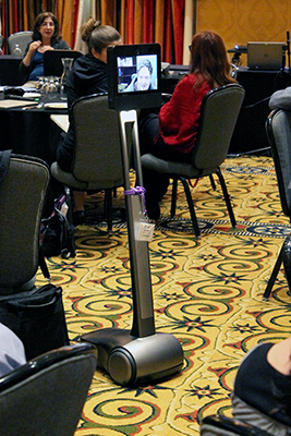 Someone uses a Beam Robot to move around the conference room.