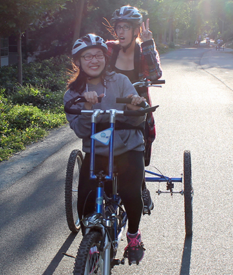 Phase II Scholars, Chana and Katelyn try out a two-person accessible bicycle during Summer Study 2016.