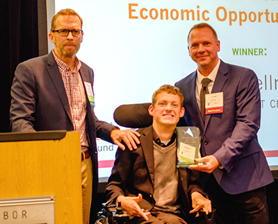 -	Michael Richardson and Daman Wandke present Scott Bellman with the Frances Pennell Economic Opportunity Award.