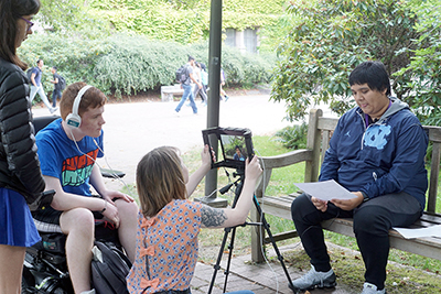 Phase II Scholar PJ, with help of instructor Courtney, films fellow Phase II Scholar Camilo during the Rooted In Right workshop during Summer Study 2018.