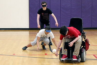 Scholars Ryan, Takashi, and Jonah try to locate the beeping baseball while wearing blindfolds during Summer Study.