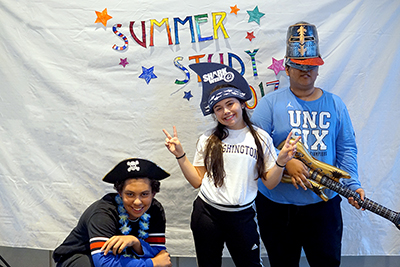 Scholars Desmond, Hayley, and Camilo strike a pose for the photo booth during Summer Study 2017.