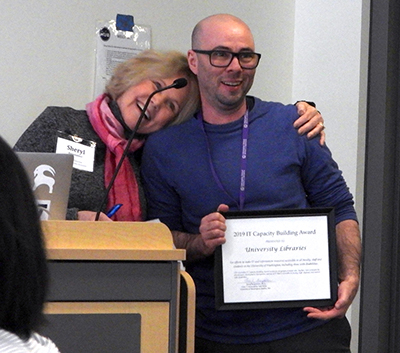 Sheryl Burgstahler presents award to Andy Andrews.