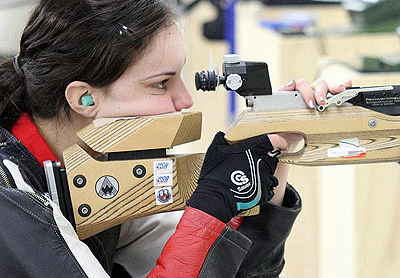 DO-IT Scholar McKenna looks through the viewfinder on a competition rifle Photo of McKenna looking through the viewfinder on a competition rifle