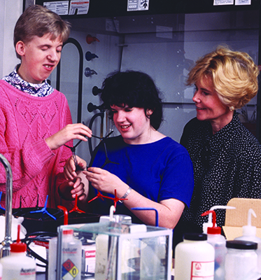 Sheryl helps two students complete a science experiment during Summer Study 1995.