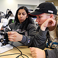 Two students use a microscope.