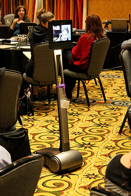 Brad shown on the screen of a Beam Robot in the middle of the conference room.