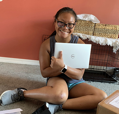 Jaida showing off her laptop she received through the DO-IT program.