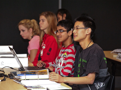 Photo of four students engaging with DO-IT director Sheryl Burgstahler's discussion on disability issues