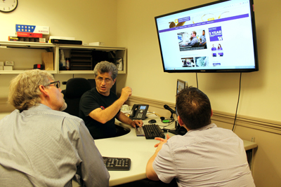 Hadi Rangin shows two UW faculty members how to make their website more accessible.